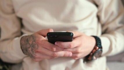 Poster - Close-up of using a mobile phone with one hand. The guy scrolls his finger across the screen. Spending free time watching visual content. Camera movement.