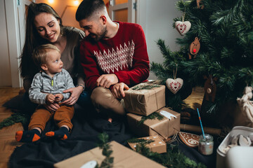 family decorating christmas tree and preparing presents at home