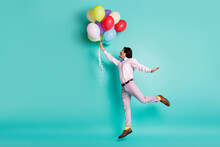 Portrait Of Jumping Young Man Hold Colorful Helium Balloons Wear Formal Outfit Yellow Socks Isolated On Turquoise Background