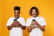© Drobot Dean - Portrait of a two happy young men holding mobile phones