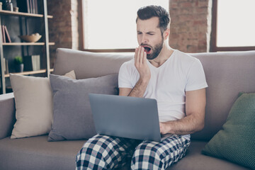 Canvas Print - Photo of exhausted man sit divan work remote laptop tired prepare startup progress innovation report yawn mouth hand wear sleepwear nightwear in house room indoors