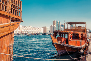 Wall Mural - Skyline view of Dubai Creek with traditional boats and piers. Sunny summer day. Famous tourist destination in UAE.