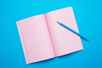 Wall Mural - open notepad with empty pink sheets on a blue background