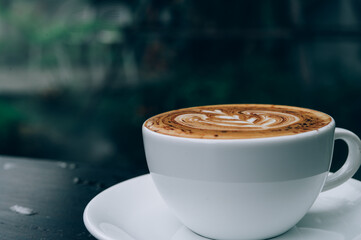 A Cup of hot latte art coffee on wooden table