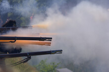 Flintlock Muzzle Loader Muskets Guns Firing. Smoke From The Gunpowder Fills The Air.