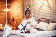© prostooleh - Beautiful girl in a decorated room. Woman sitting on a bed. Black lady in a white blouse