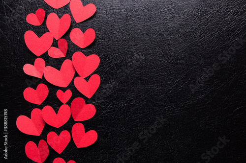 A lot of small hearts of red color against a black isolated background. Happy Valentine\'s Day.