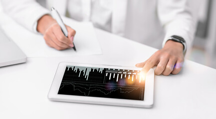 Fototapete - Unrecognizable woman using tablet computer with business diagrams and taking notes