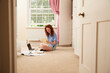 © Himalayan Pics/Caia Image - Preteen girl doing homework at laptop on bedroom floor