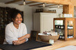 © Martin Barraud/Caia Image - Portrait happy confident female shop owner at counter