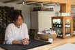 © Martin Barraud/Caia Image - Thoughtful female shop owner behind counter