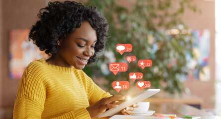 African Woman Using Social Media On Tablet Sitting In Cafe