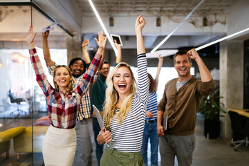 group of successful happy business people in office celebrating profits