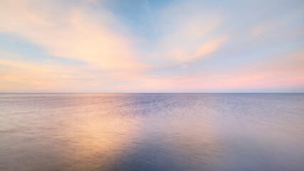 Wall Mural - Baltic sea under the colorful sunset sky. Stunning seascape. Golden sunset light through the pink clouds. Long exposure. Tranquility scene. Riga bay, Latvia