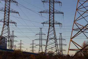 Electric powerlines. High voltage power lines, pylons on blue sky background