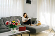 © Javier D√≠ez/Stocksy - Asian woman reading on sofa