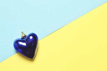 Wall Mural - Christmas heart decoration on yellow and blue paper background