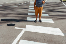 Boy Holding Balloon While Standing At Crosswalk In City