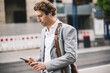 © UWE_UMSTAETTER/Westend61 - Businessman using mobile phone while standing in city