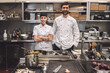 © Maskot - Portrait of smiling male and female chefs in commercial kitchen