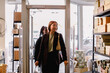 © Maskot - Smiling female friends entering retail store