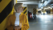 © CameraCraft - Young scared blond woman using smartphone in the garage. High quality photo