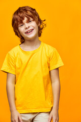 Wall Mural - Joyful boy with red hair bent over to the side cropped view