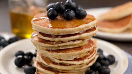 Wall Mural - Stack of pancakes with blueberries and honey on a plate. Tasty fluffy american pancakes. Breakfast food