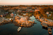 Aerial Sunset View Of A Small Rocky Bay With  Red Boat Houses  Anchored Boats In Hönö, Gothenburg Archipelago, Sweden.
