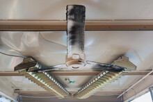 Old Three - Blade Ceiling Fan With Lights In The Background.