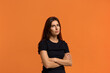 © 5M - It is a big problem for me. Contemplative caucasian woman in black t-shirt keeps hands crossed over chest, ponders on how to solve situation, looking for solution. Isolated over an orange background.