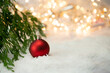 Czerwona bombka na śniegu. Dekoracja na Boże Narodzenie, świąteczny klimat.