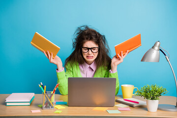 Poster - Frustrated girl sit table hold notebook cry wear green shirt isolated blue color background