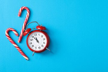 Poster - Alarm clock and candy canes on light blue background, flat lay with space for text. New Year countdown