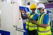 © ake1150 - Asian industrial engineers and worker in hard hats discuss product line while using digital tablet in cnc milling cutting machine in a heavy industry manufacturing factory.