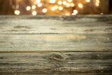 Fototapeta  - Pusty stół drewniany z rozmytym tłem ze światełkami i lampkami o ciepłej barwie na święta