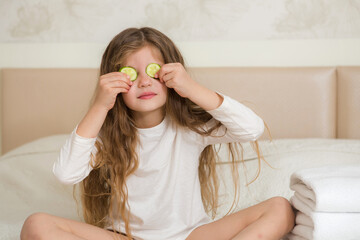 Portrait of a happy smiling child girl. Cute 5 years girl relaxing on the bed. Skin care concept.