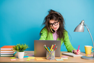 Canvas Print - Portrait of overworked girl sit table work laptop write note book wear green shirt isolated on blue color background