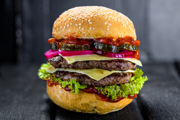 big burger with two cutlets on black background
