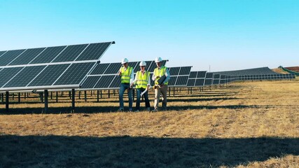Engineers working at solar energy plant. Solar power plant workers, solar energy industry concept.