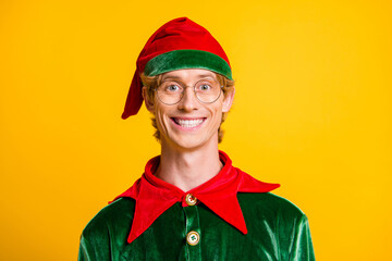 Canvas Print - Photo of young handsome guy toothy beaming smile camera wear elf velvet green costume headwear glasses isolated yellow color background