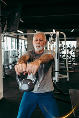 Senior man exercising at gym.