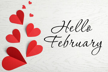 greeting card with text hello february. red paper hearts on white wooden background, flat lay