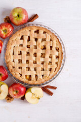 Wall Mural - Traditional American Thanks Giving pie, whole & halved apples, cinnamon sticks, anise seeds. Homemade fruit tart baked to golden crust with ingredients. Close up, copy space, top view, background.