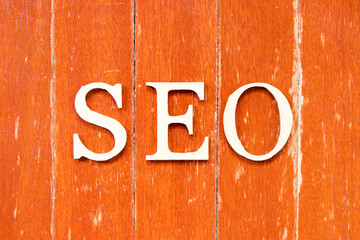 Poster - Alphabet letter in word SEO (Abbreviation of search engine optimization) on old red color wood plate background