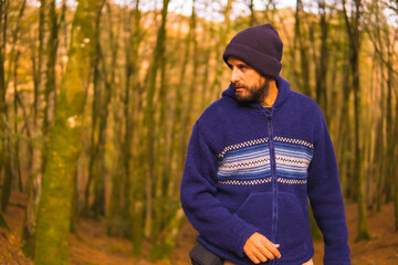 Wall Mural - Lifestyle, a young man in a blue wool sweater and a hat enjoying the forest in autumn. Artikutza Forest in San Sebastián, Gipuzkoa, Basque Country. Spain
