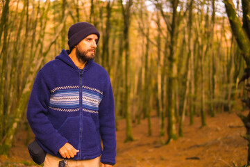Wall Mural - Lifestyle, a young man in a blue wool sweater enjoying the forest in autumn. Artikutza Forest in San Sebastián, Gipuzkoa, Basque Country. Spain