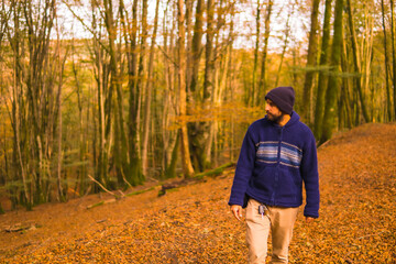 Wall Mural - Lifestyle, a young man in a blue wool sweater enjoying the forest in autumn. Artikutza Forest in San Sebastián, Gipuzkoa, Basque Country. Spain
