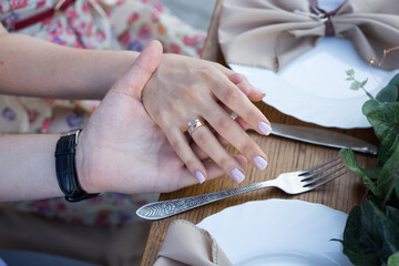 Wall Mural - newlyweds hold hands over the table