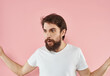 © SHOTPRIME STUDIO - Bearded man on a pink background gesturing with his hands and a white T-shirt cropped view